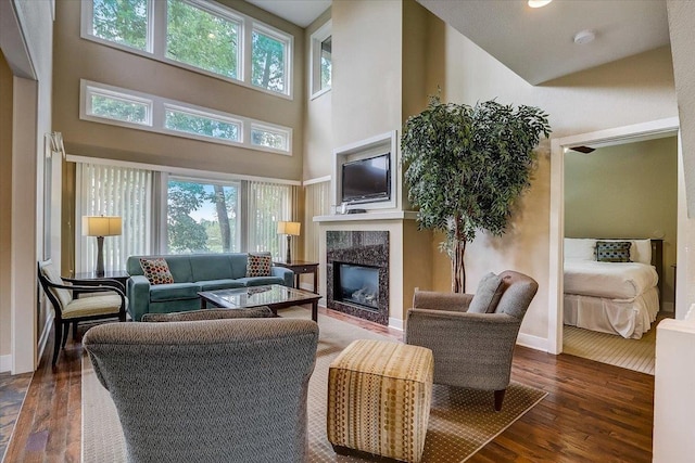 living room featuring a high ceiling, a premium fireplace, and dark hardwood / wood-style flooring