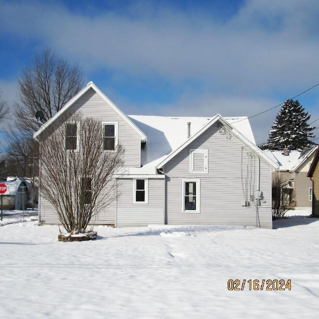 view of snow covered rear of property