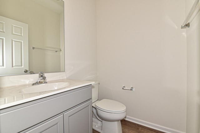 bathroom with hardwood / wood-style floors, vanity, and toilet