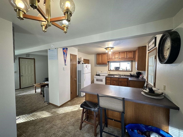 kitchen with white appliances, kitchen peninsula, tile floors, and sink