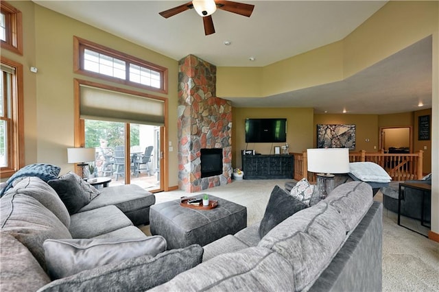 living room featuring a fireplace, light carpet, and ceiling fan