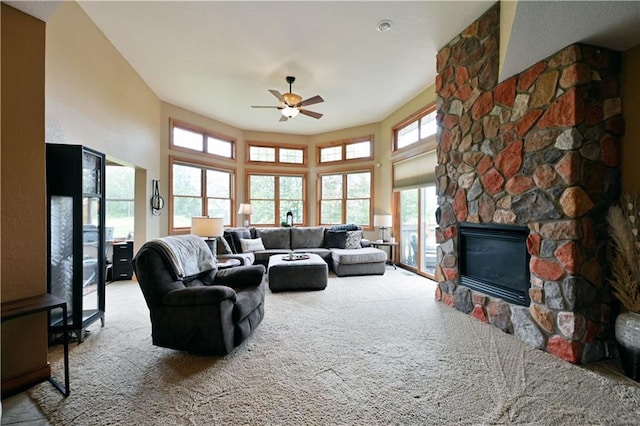 living room featuring light colored carpet, ceiling fan, and a fireplace