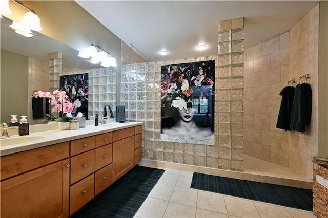 bathroom with tile flooring, vanity with extensive cabinet space, tile walls, dual sinks, and a tile shower