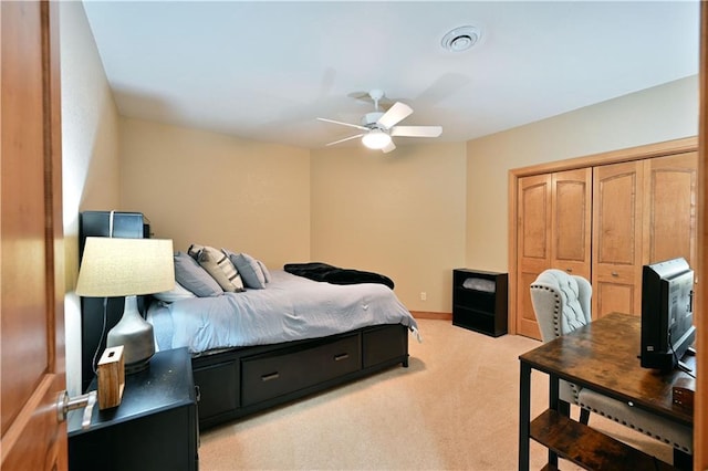 bedroom featuring ceiling fan, light carpet, and a closet