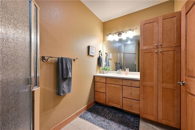 bathroom with tile floors, oversized vanity, and a shower with shower door