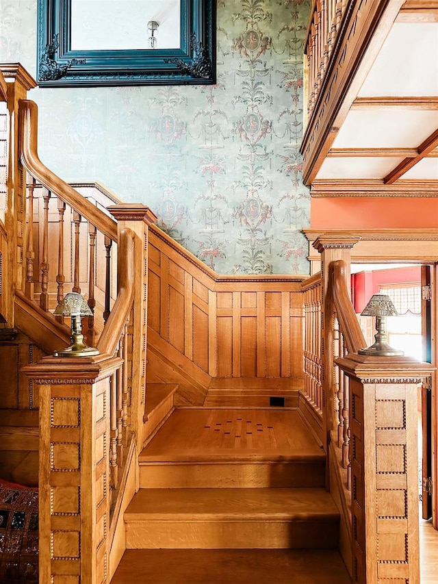 staircase featuring coffered ceiling and dark wood-type flooring