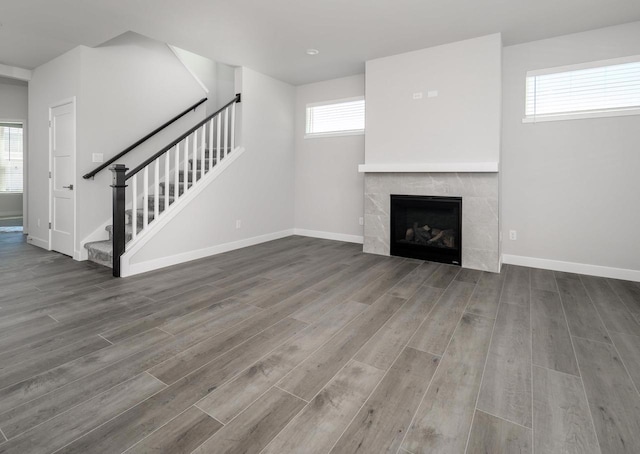 unfurnished living room featuring a tile fireplace and wood-type flooring