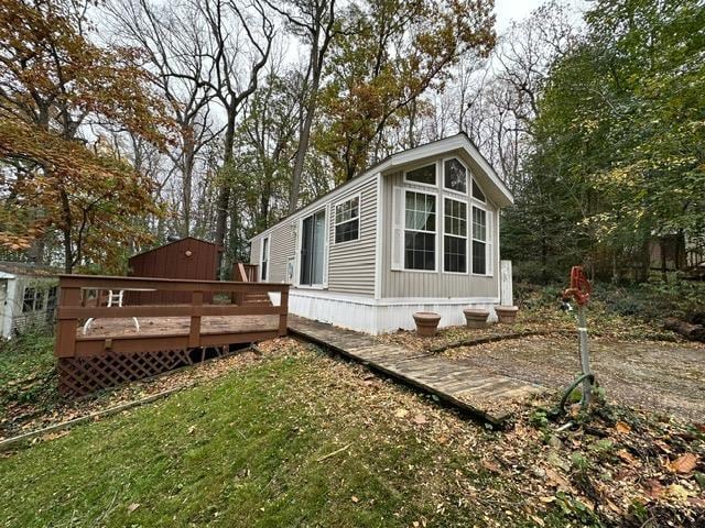 view of property exterior featuring a deck and a yard