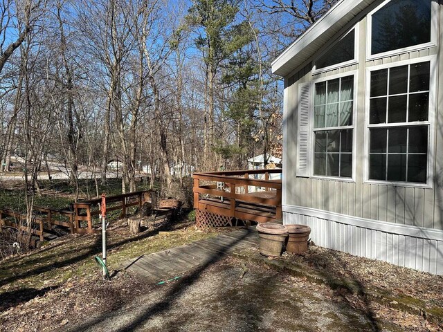 back of house featuring a wooden deck and a lawn