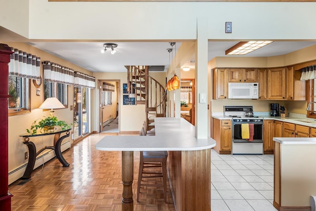 W1188 Spring Grove Rd, Green Lake, WI 54971 - kitchen with light tile floors, a breakfast bar, a baseboard radiator, white appliances, and sink