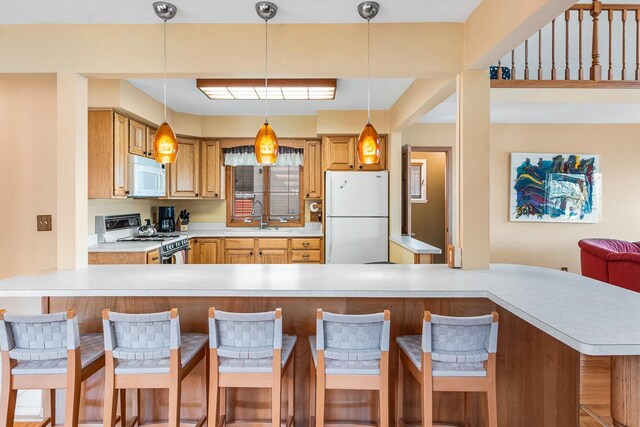 W1188 Spring Grove Rd, Green Lake, WI 54971 - kitchen featuring decorative light fixtures, a kitchen breakfast bar, white appliances, and sink
