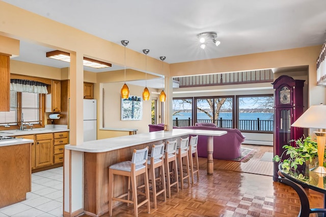 W1188 Spring Grove Rd, Green Lake, WI 54971 - kitchen with light parquet flooring, plenty of natural light, hanging light fixtures, and a kitchen bar