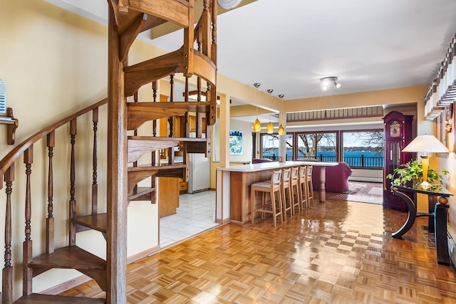W1188 Spring Grove Rd, Green Lake, WI 54971 - kitchen with hanging light fixtures, a breakfast bar, kitchen peninsula, and light parquet floors
