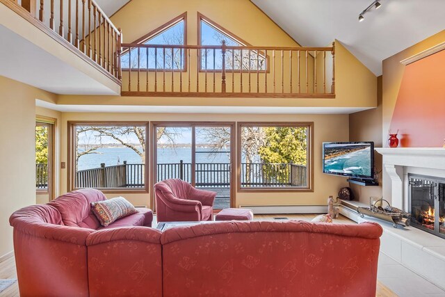 W1188 Spring Grove Rd, Green Lake, WI 54971 - tiled living room featuring a water view, a healthy amount of sunlight, track lighting, and a high ceiling