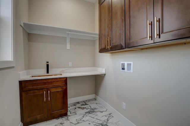 laundry area featuring light tile flooring, sink, cabinets, and washer hookup