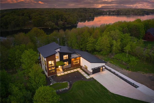 aerial view at dusk featuring a water view