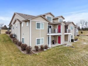 view of front of home with a balcony and a front lawn