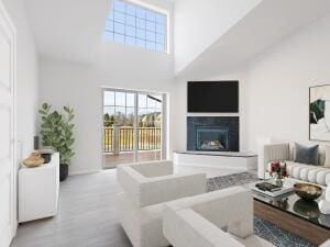 living room with a towering ceiling and light wood-type flooring