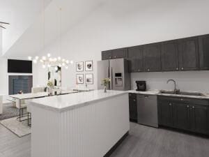 kitchen with a kitchen island, high vaulted ceiling, hardwood / wood-style flooring, and stainless steel appliances