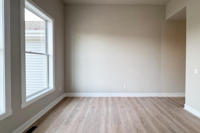 empty room with light hardwood / wood-style flooring and a healthy amount of sunlight