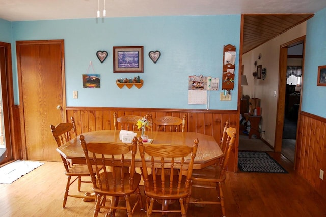 dining room with wooden walls and hardwood / wood-style floors