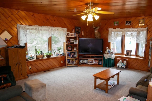 carpeted living room featuring ceiling fan, wood ceiling, and wood walls