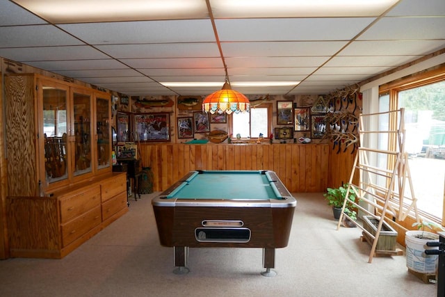 game room featuring a drop ceiling, wooden walls, and carpet floors