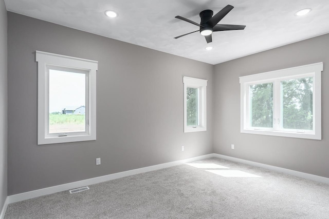 carpeted spare room featuring ceiling fan