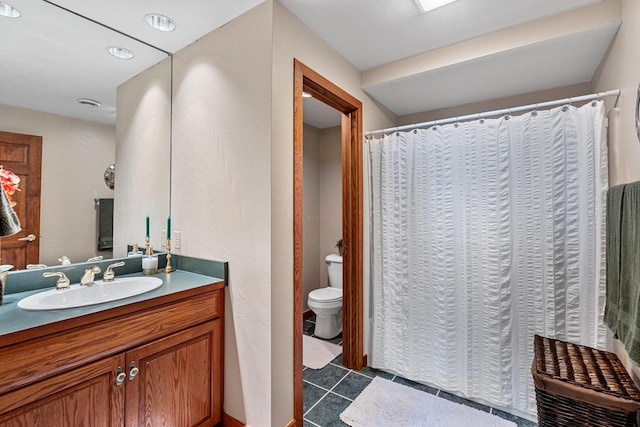 bathroom featuring tile flooring, toilet, and vanity