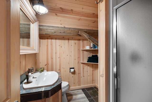 bathroom with tile floors, toilet, large vanity, and wooden walls