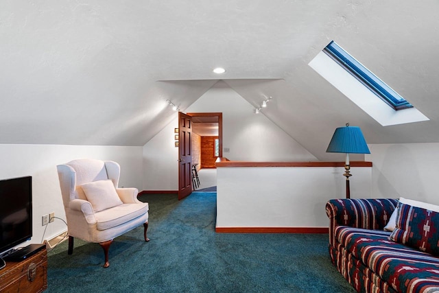 sitting room featuring vaulted ceiling with skylight and dark colored carpet