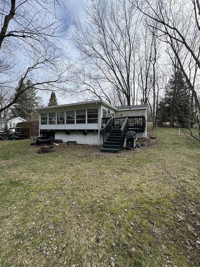 rear view of property featuring a lawn and a wooden deck