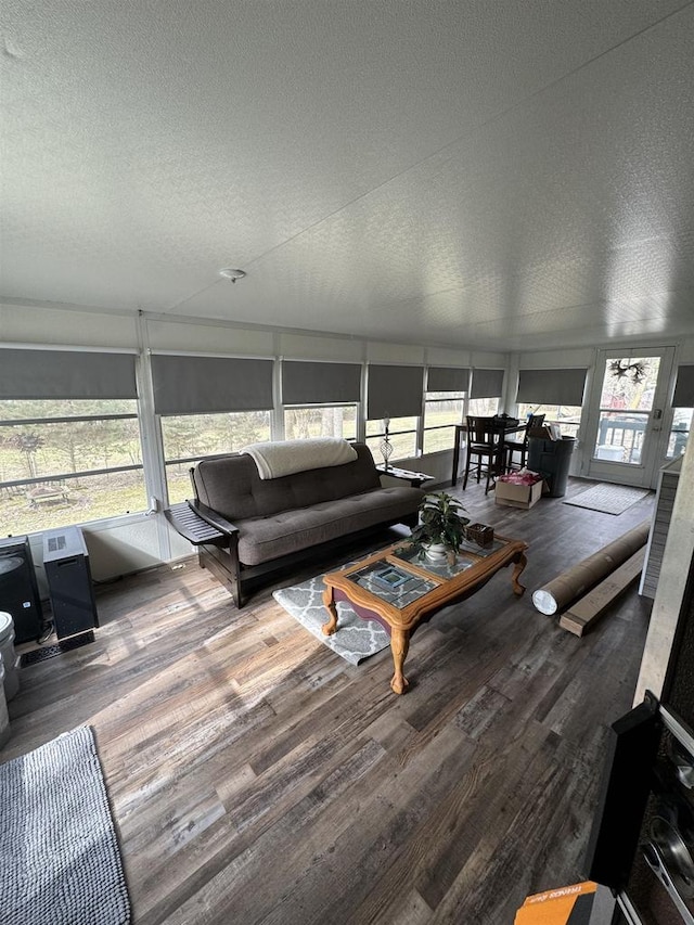 living room with a textured ceiling and dark wood-type flooring