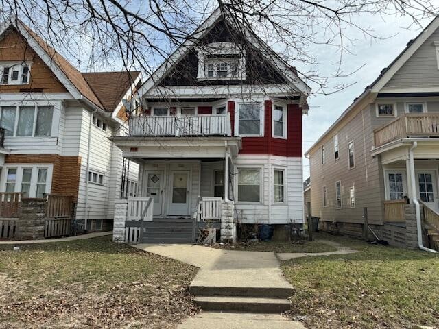 view of front of house featuring a front yard and a balcony