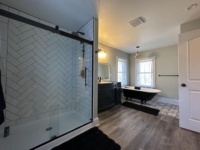 bathroom featuring wood-type flooring, a shower with shower door, and vanity