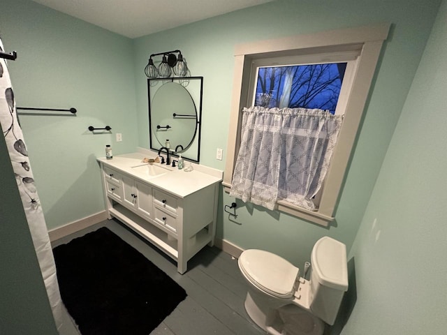 bathroom featuring toilet, hardwood / wood-style flooring, and vanity