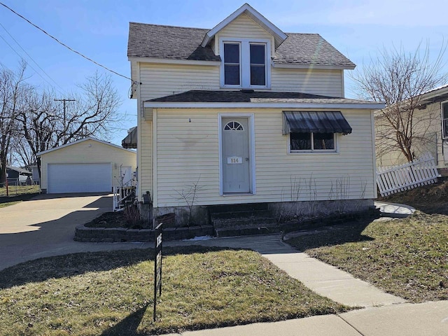 view of front facade featuring a front yard, an outdoor structure, and a garage