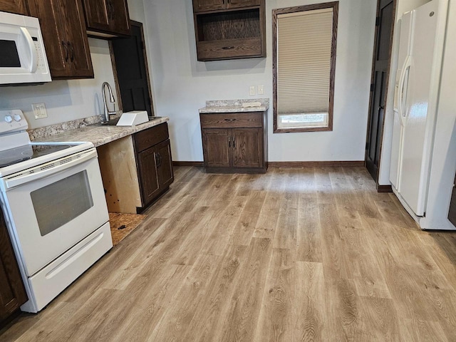 kitchen featuring dark brown cabinetry, light hardwood / wood-style flooring, and white appliances