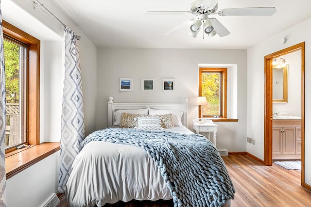 bedroom featuring ceiling fan, light wood-type flooring, and ensuite bath