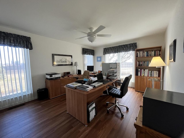 home office featuring plenty of natural light, ceiling fan, and dark hardwood / wood-style floors