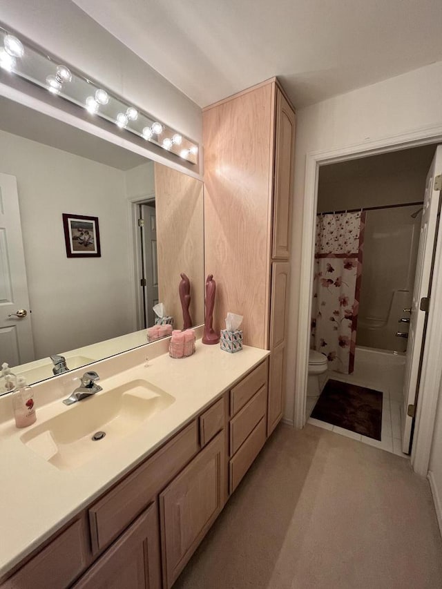 bathroom with toilet, tile floors, and vanity with extensive cabinet space