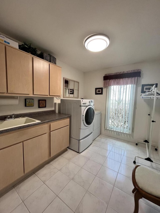 laundry area featuring separate washer and dryer, sink, light tile flooring, and cabinets