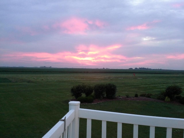 yard at dusk featuring a rural view