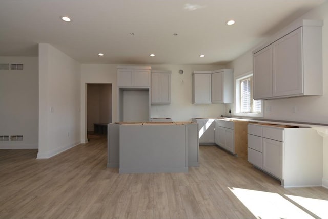 kitchen with gray cabinets, light hardwood / wood-style flooring, and a center island