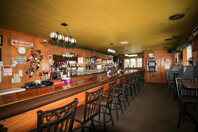 bar featuring wooden walls and dark colored carpet