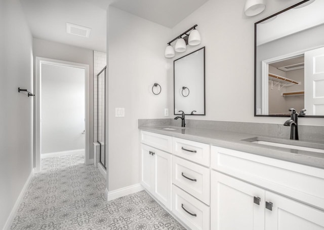 bathroom featuring tile patterned flooring, vanity, and walk in shower