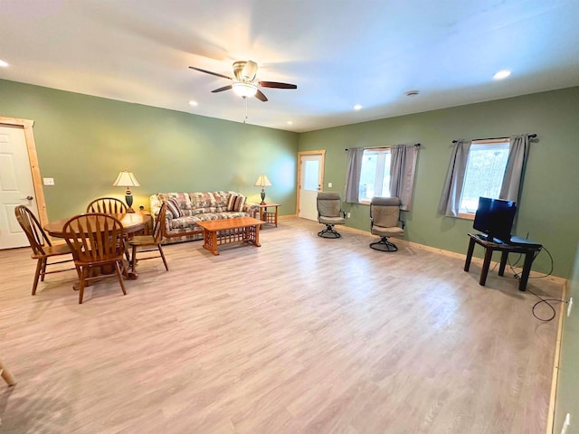 living room with light hardwood / wood-style flooring and ceiling fan