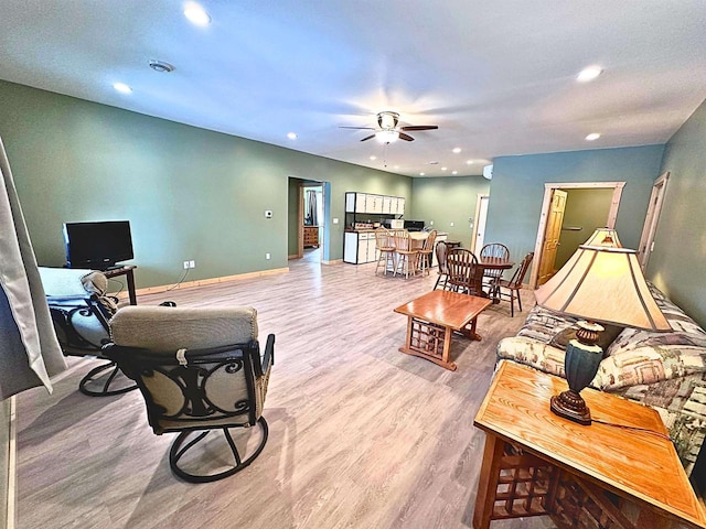 living room with ceiling fan and light hardwood / wood-style flooring