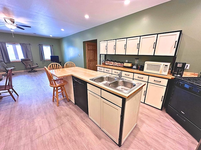 kitchen featuring white cabinetry, dishwasher, sink, light hardwood / wood-style floors, and a kitchen island