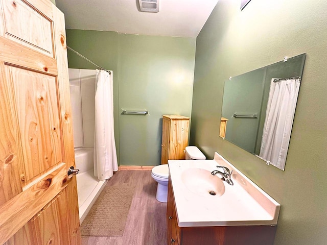 bathroom featuring hardwood / wood-style floors, a shower with curtain, toilet, and vanity